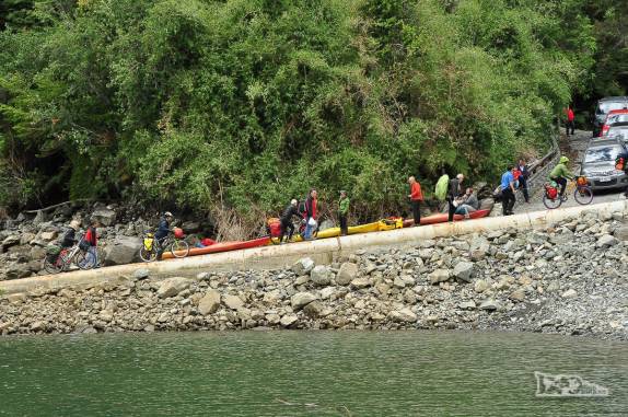 Ciclistas desembarcam enquanto carros esperam a hora de embarcar na balsa de Fiordo Largo, no sul do Chile